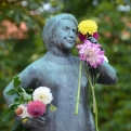 Decorated statue next to a market stall selling flowers