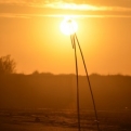 Makeshift tripod on beach with setting sun